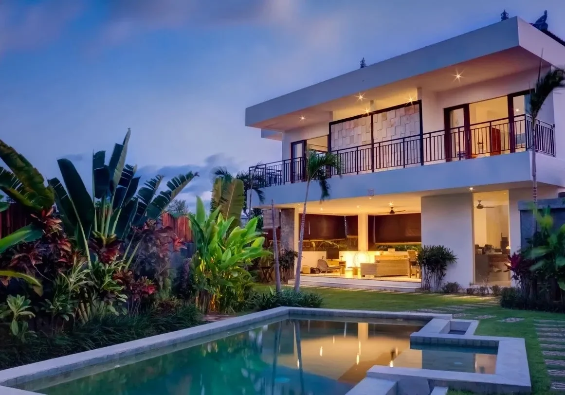 A modern house with a pool at dusk.